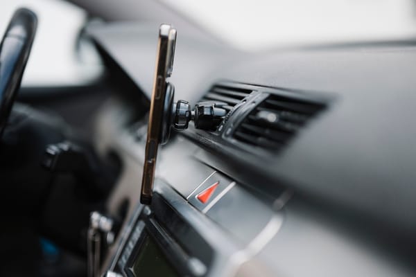 Smartphone agganciato al cruscotto dell'auto con un'app di navigazione aperta