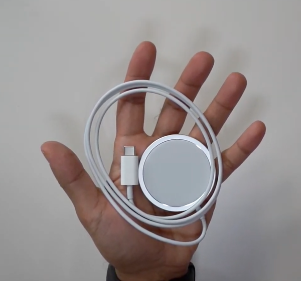 Il caricatore Apple MagSafe per iPhone con il cavo USB-C tenuto in mano