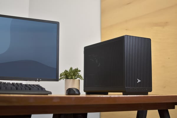 Scrivania in legno con monitor, tastiera e computer desktop, simbolo della postazione da cui nasce il blog