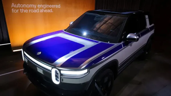 Un prototipo Rivian R2 esposto a un evento sulla guida assistita, con la scritta Autonomy engineered for the road ahead sullo sfondo.