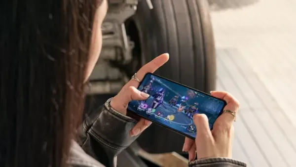 Persona che gioca a un titolo d’azione su uno smartphone tenuto in orizzontale