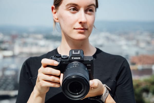 Una persona tiene in mano la mirrorless Canon EOS R8 Mark II con obiettivo RF zoom