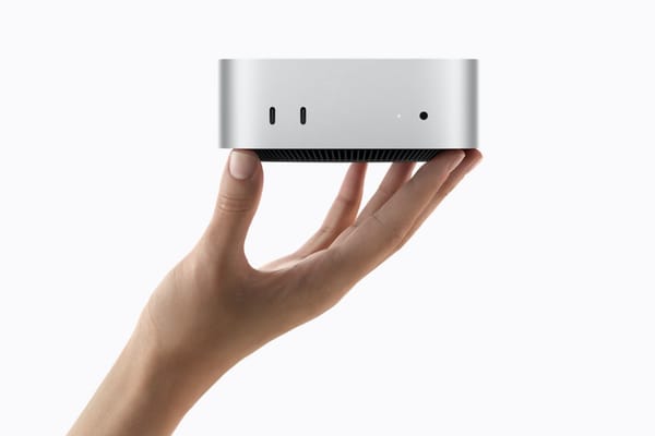 Mac mini M6 argento mostrato dal basso, sorretto da una mano