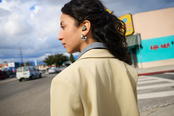 Persona con Pixel Buds Pro 2 color oliva durante una passeggiata urbana