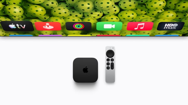 Apple TV 4K nera e telecomando Siri Remote davanti a una schermata con app, nell’immagine ufficiale Apple.